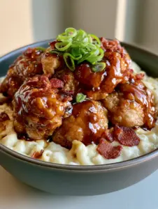 A handheld smartphone photo of creamy white mac and cheese topped with dark amber glazed chicken. (Applebee’s Honey Pepper Chicken Mac and Cheese)