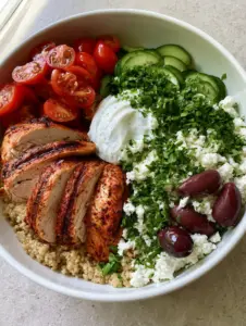 Close up of grilled chicken with char marks and fluffy quinoa in a white bowl for Mediterranean Diet Healthy Dinners.