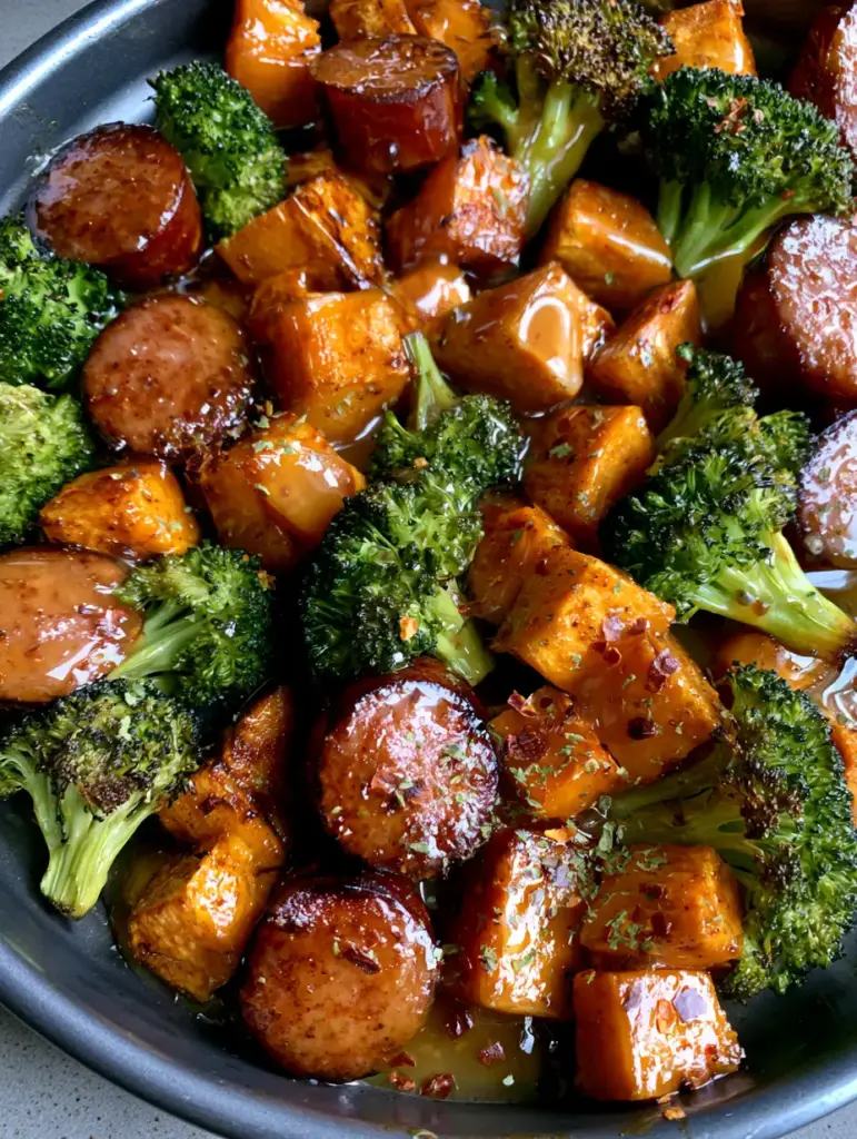 Close up of glossy amber honey garlic glaze over charred broccoli and seared sausage.