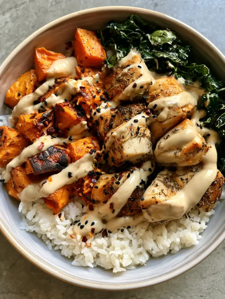 Top-down view of a Chicken Sweet Potato Power Bowl featuring golden chicken and charred sweet potato cubes.