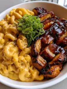 Close up photo of Honey Pepper Chicken and Macaroni Cheese showing the thick cheese sauce and scallion garnish. (Honey Pepper Chicken and Macaroni Cheese)